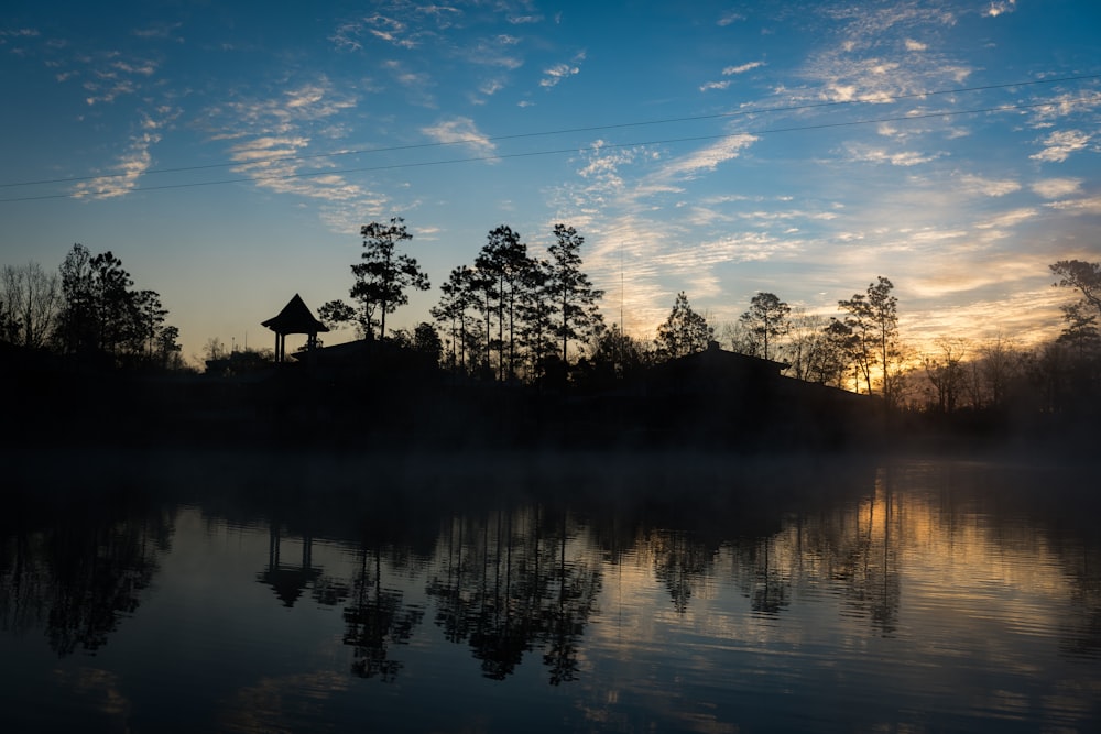 a body of water with trees and a building in the background