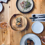 An overhead shot of a wooden table set with various traditional dishes and drinks.