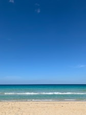 A serene beach scene with gentle waves and a clear blue sky, symbolizing tranquility and connection.