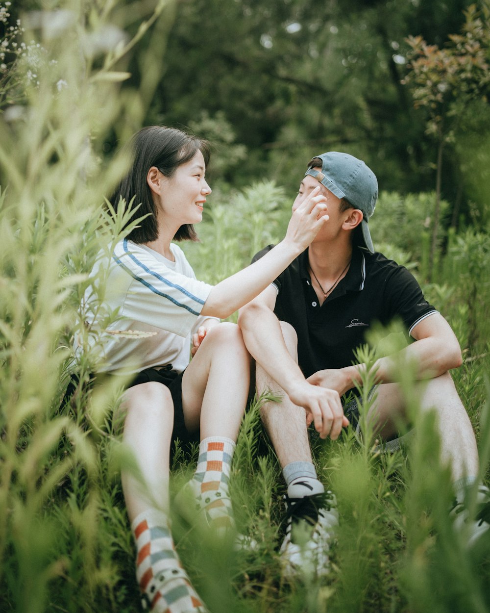 a man and woman sitting in tall grass