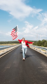 a person holding a flag on a bridge