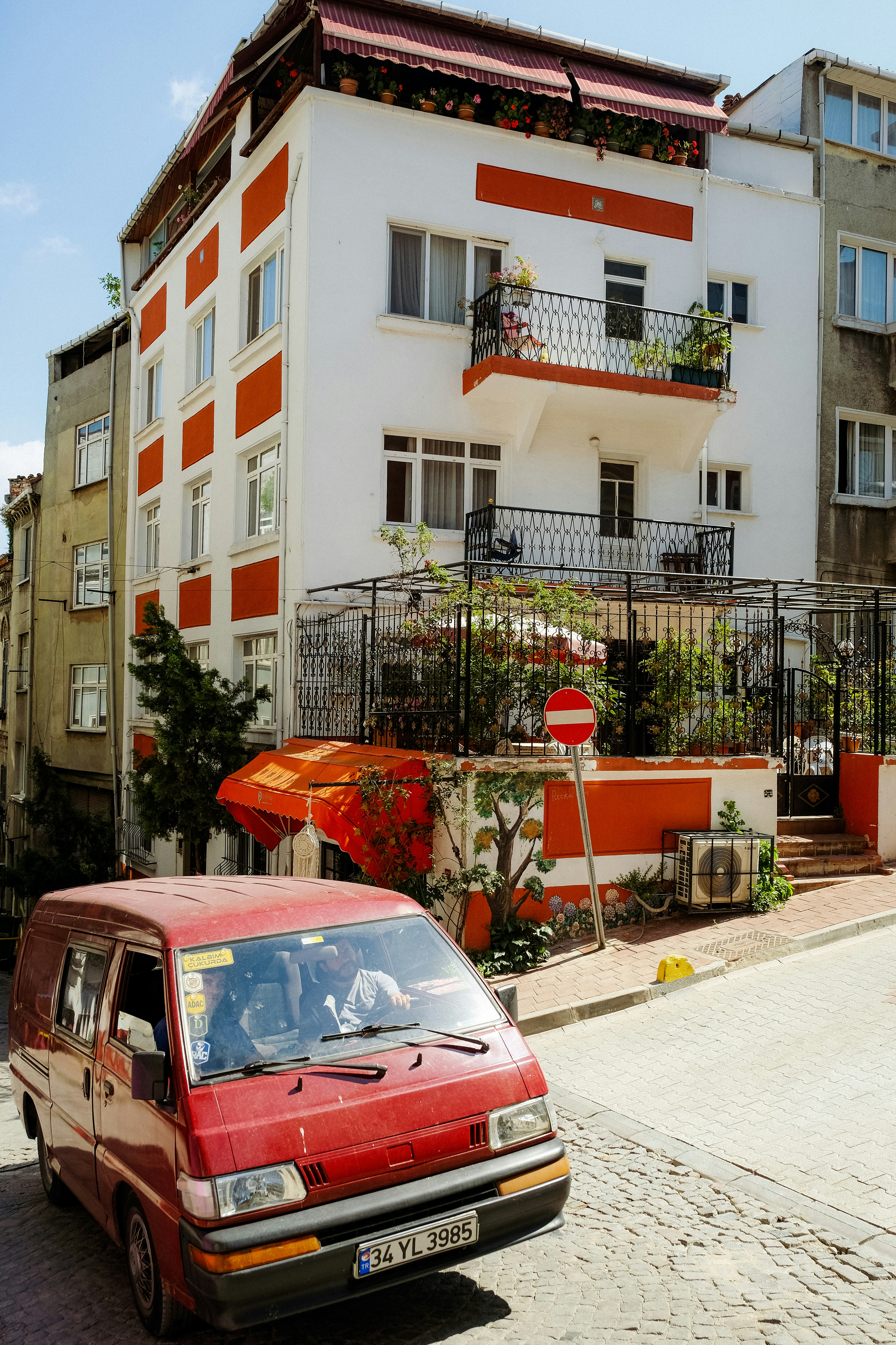 a red car parked in front of a white building