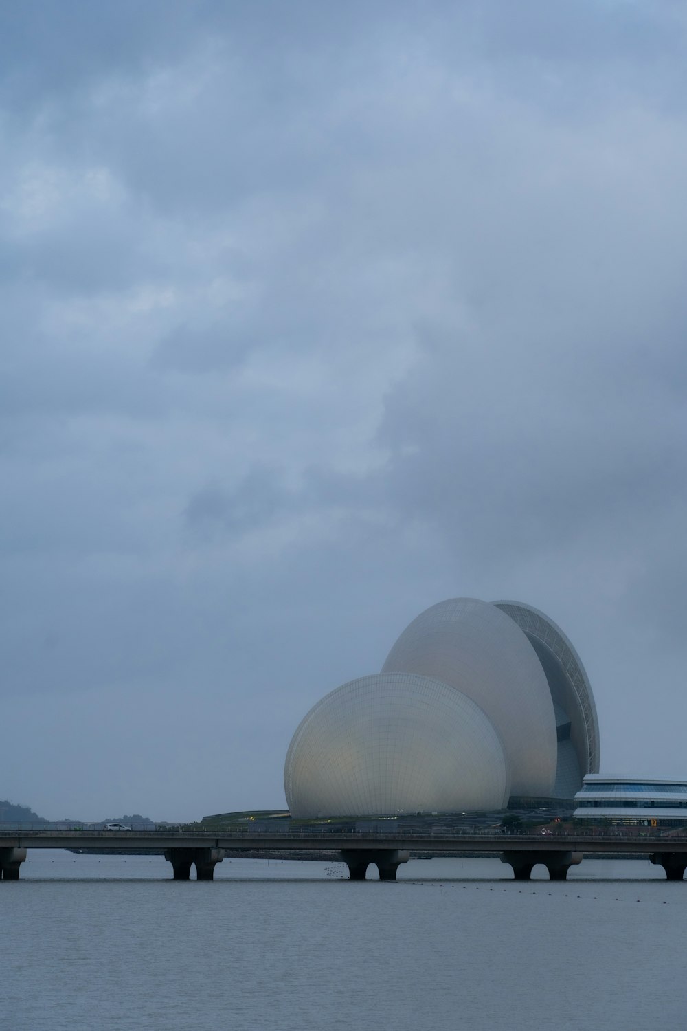 a couple of large white spherical structures by water