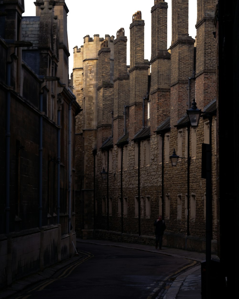 a person walking on a street between buildings