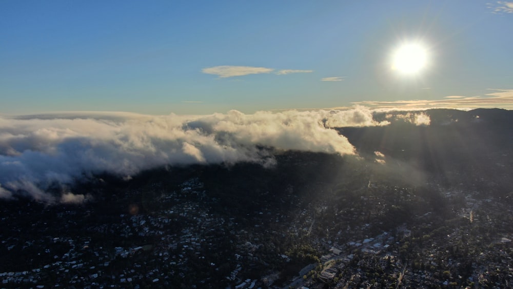 a view of a mountain range with the sun shining through the clouds