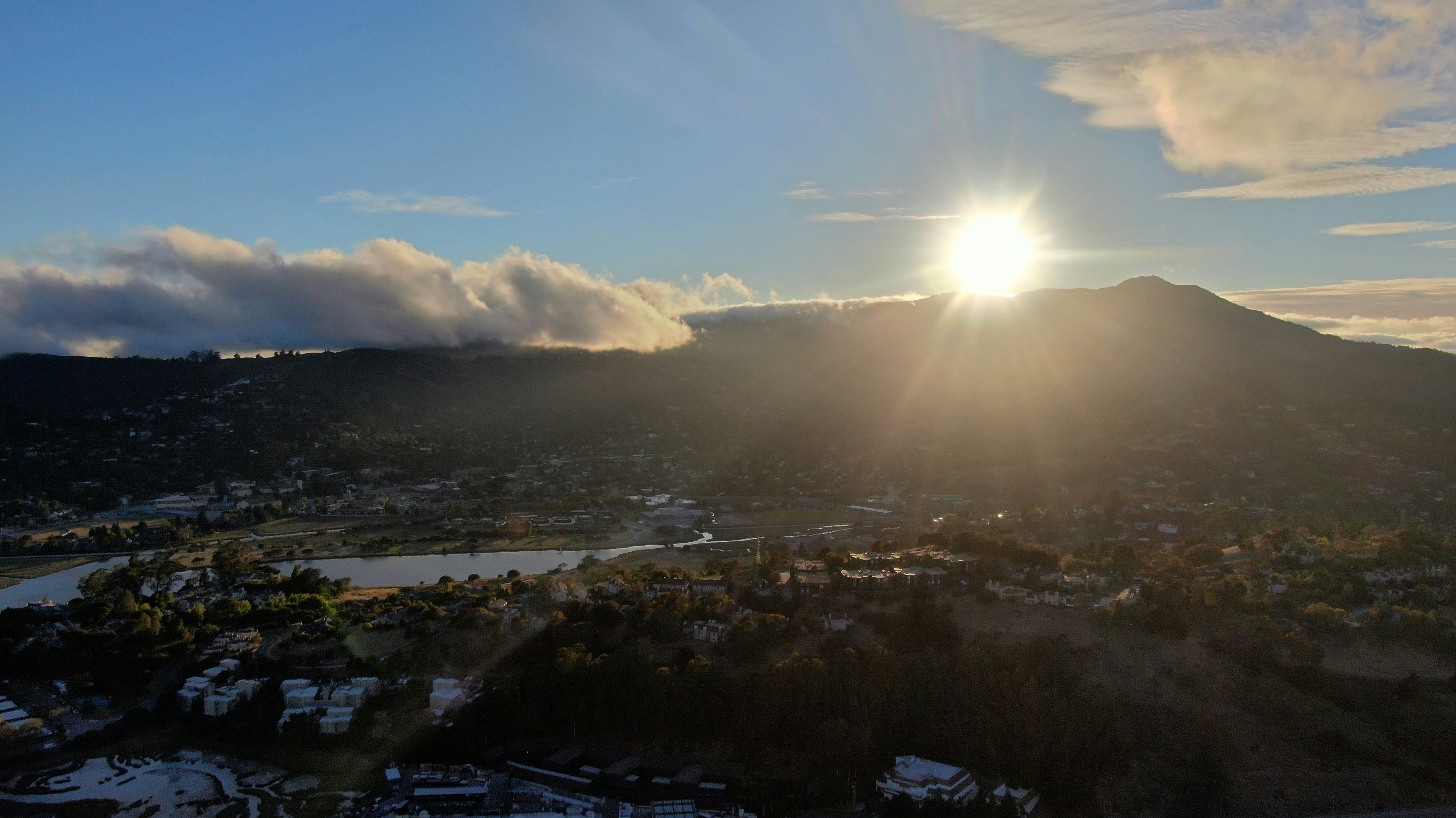 배경에 태양이있는 물과 건물이있는 풍경 사진