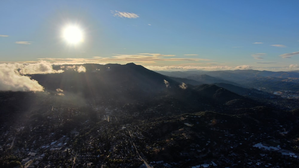 a view of a mountain range with the sun shining