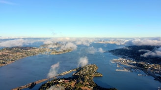 Aerial view of a coastal city with beaches and urban areas under clear sky.