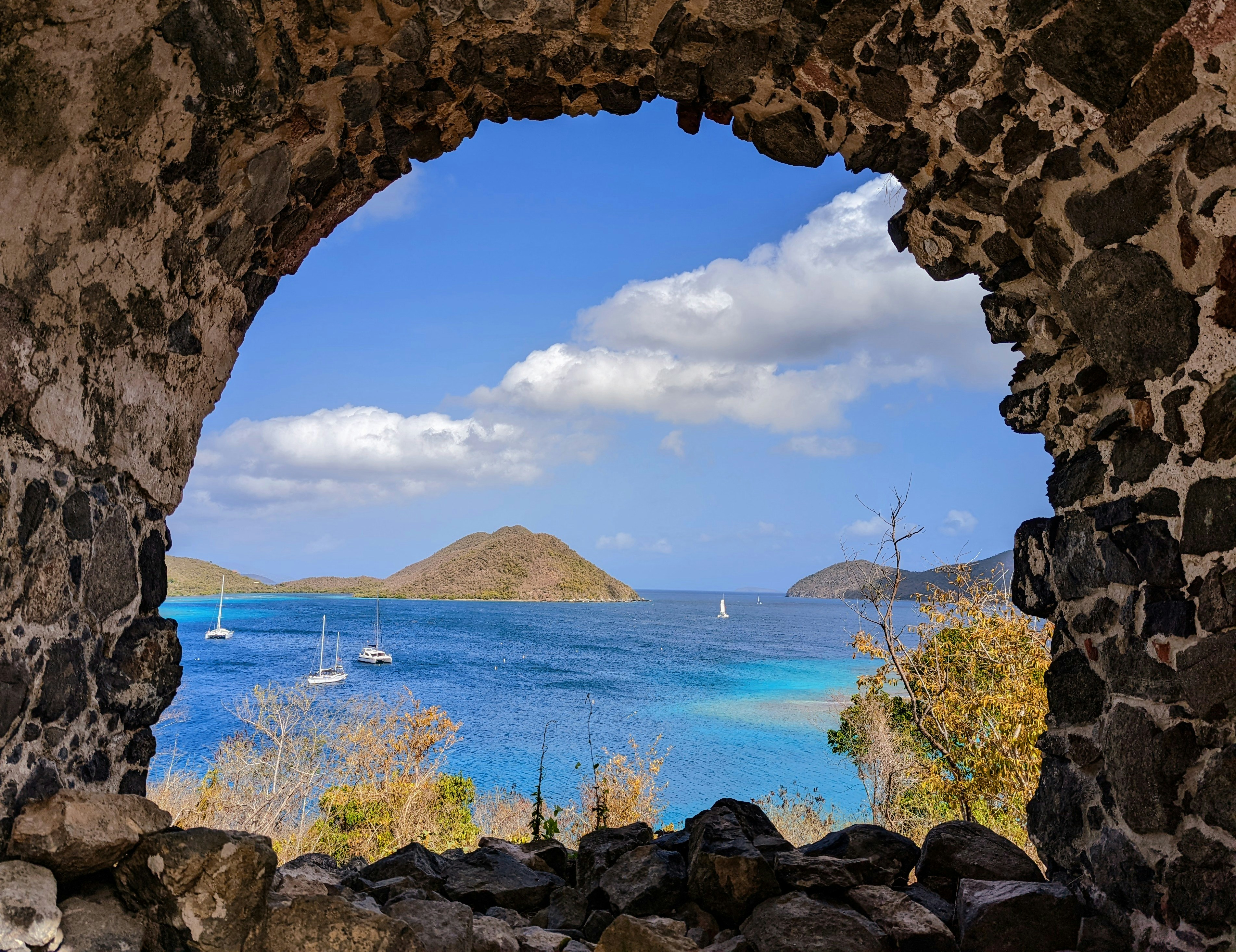 A view of a bay through a stone archway photo – Free Blue Image on Unsplash