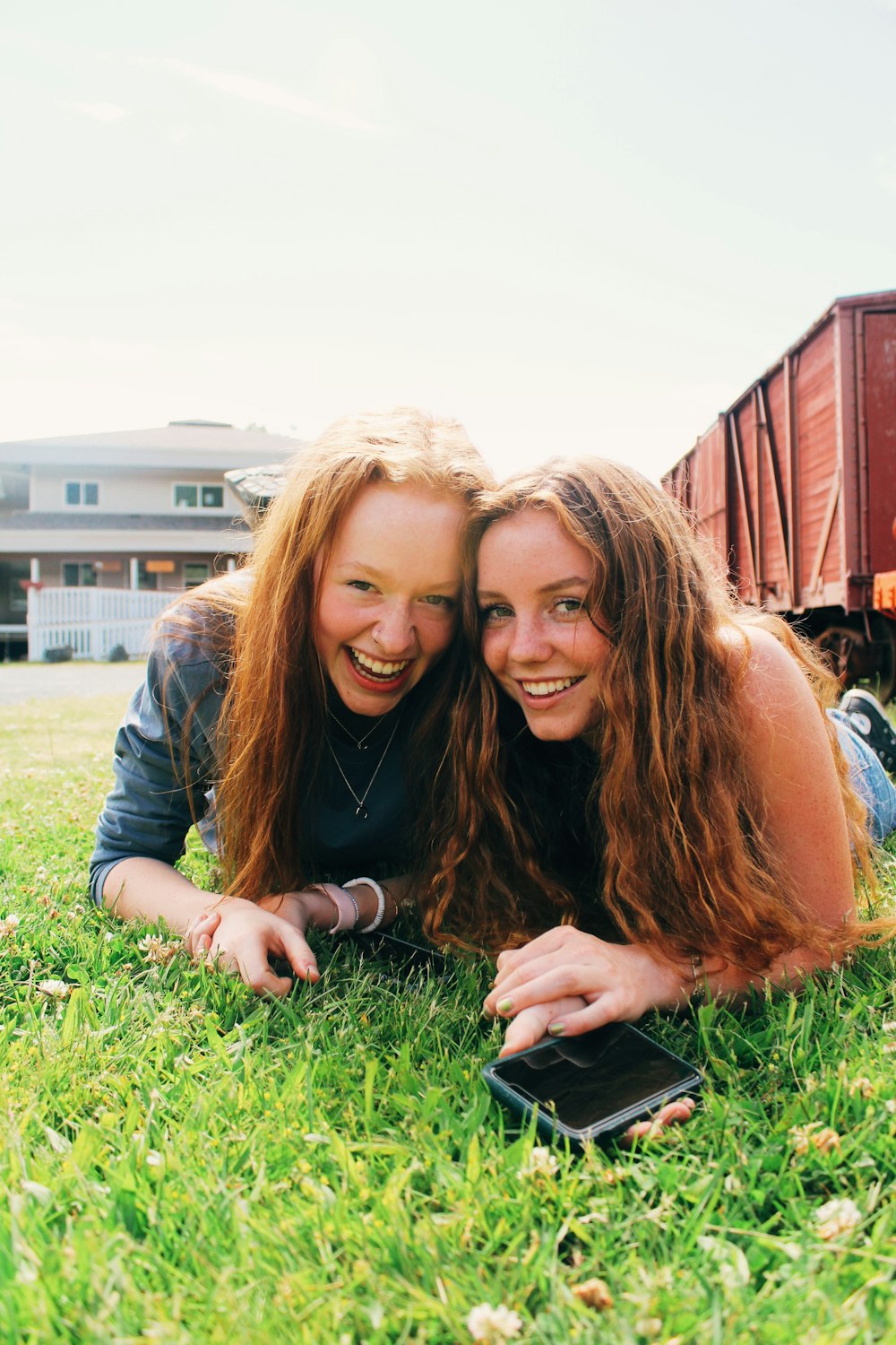 a couple of women sitting on grass