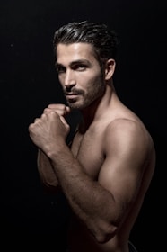 Close-up photo of a fitness warrior mid-pose, muscles tense and ready, representing combativeness and determination.