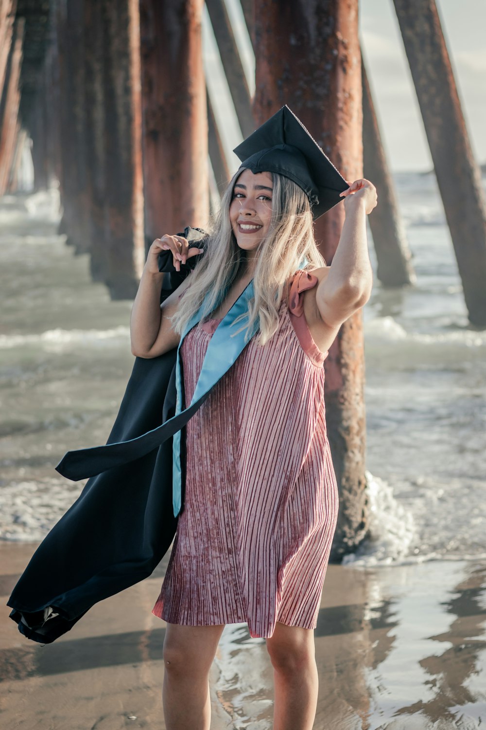 a couple of women wearing graduation gowns and standing in water