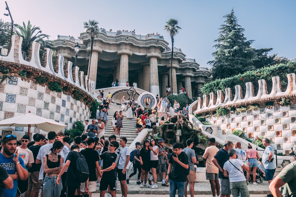 a crowd of people in front of a building with columns