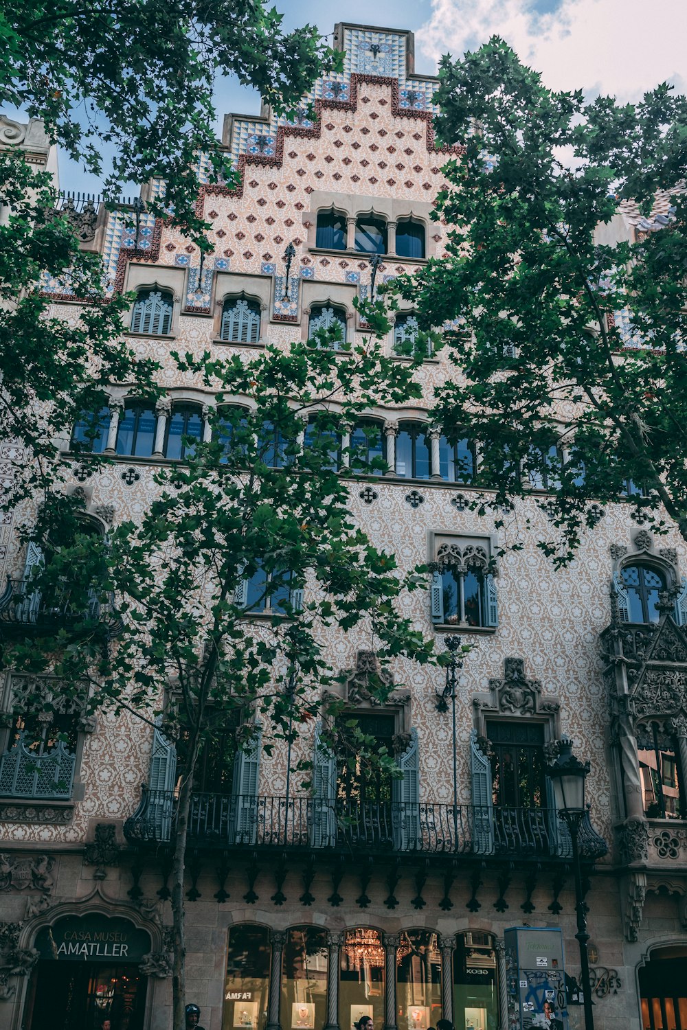 a building with many windows and trees in the front
