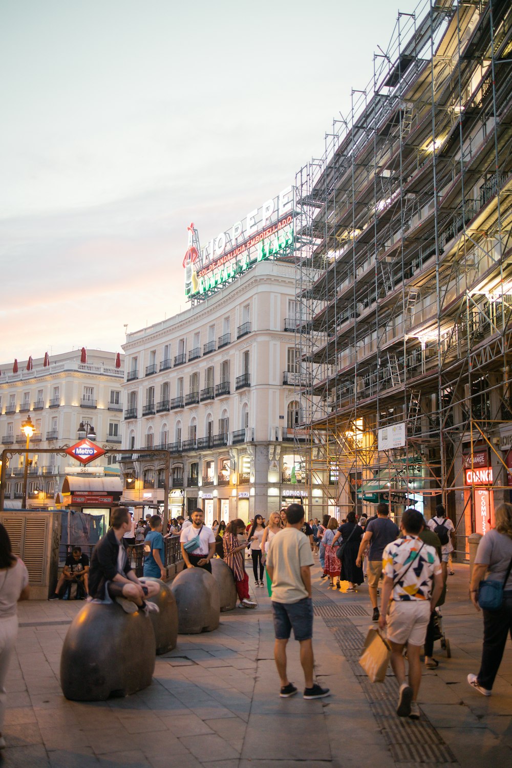 a crowd of people walking on a street in front of a building