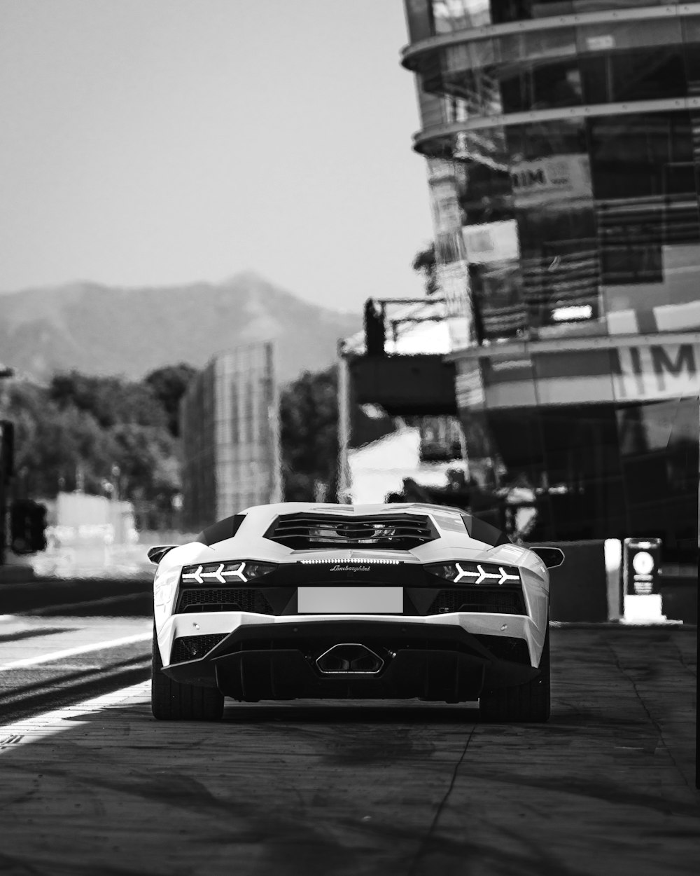 a black and white photo of a car driving on a road