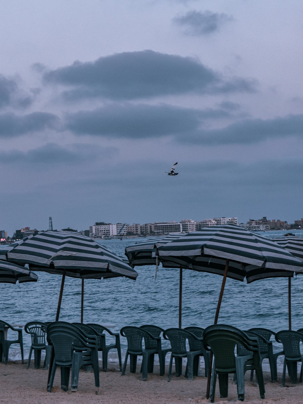 a group of tables and chairs next to a body of water