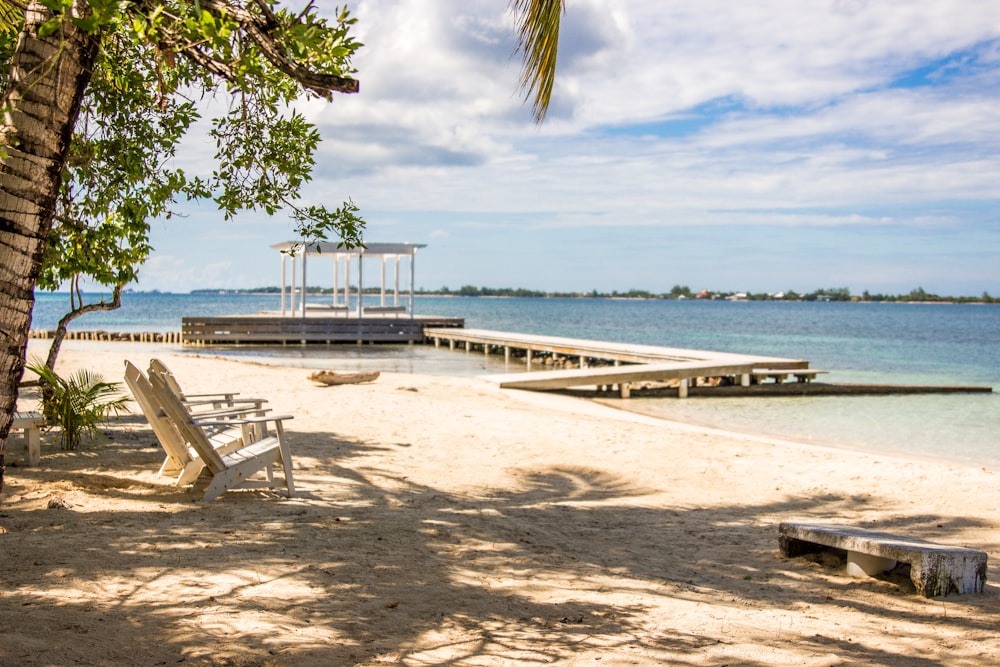 a beach with a pier and chairs