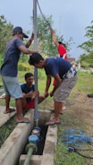 A team of plumbers discussing a project at a job site.