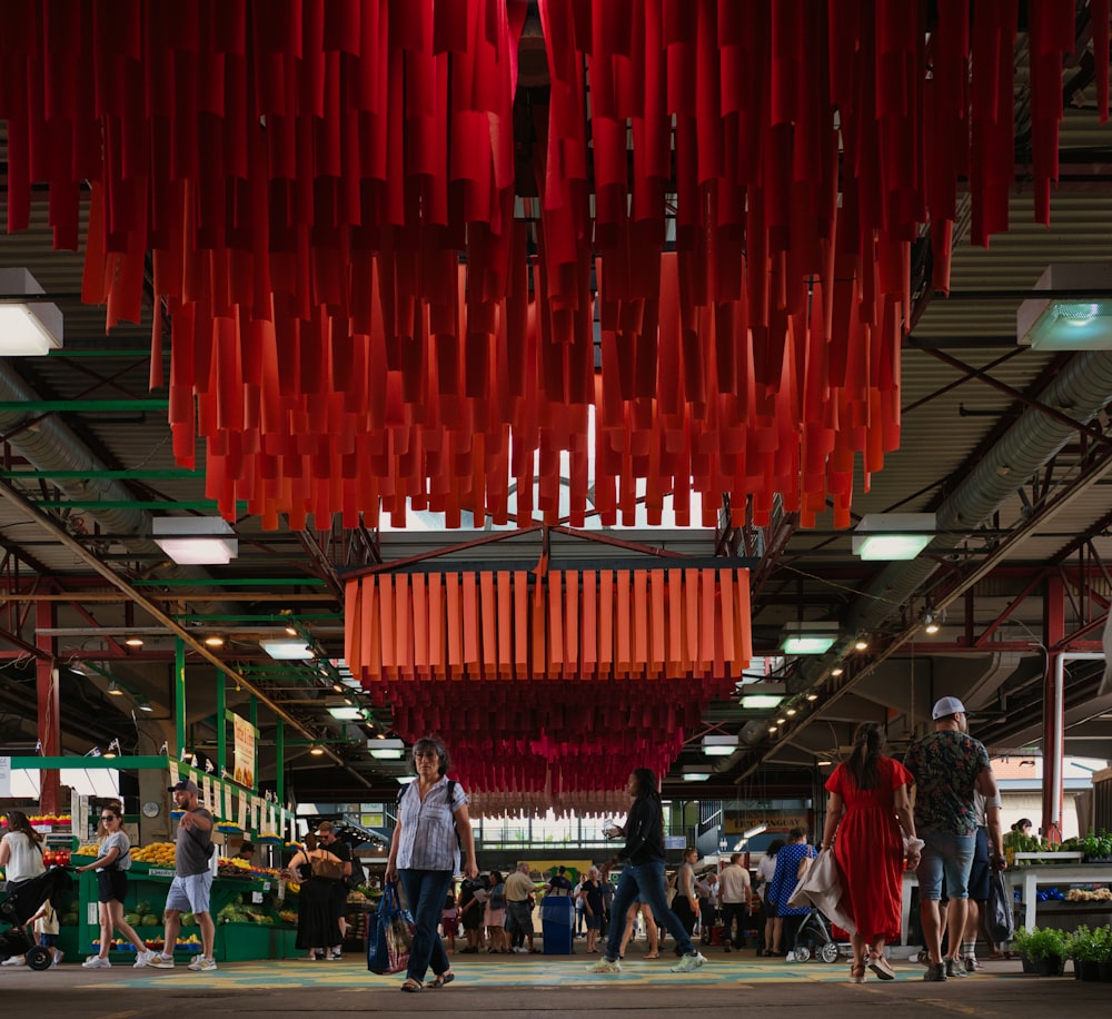 a group of people walking under a red roof