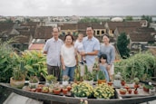 A happy family standing in front of their new home, smiling and celebrating their purchase.