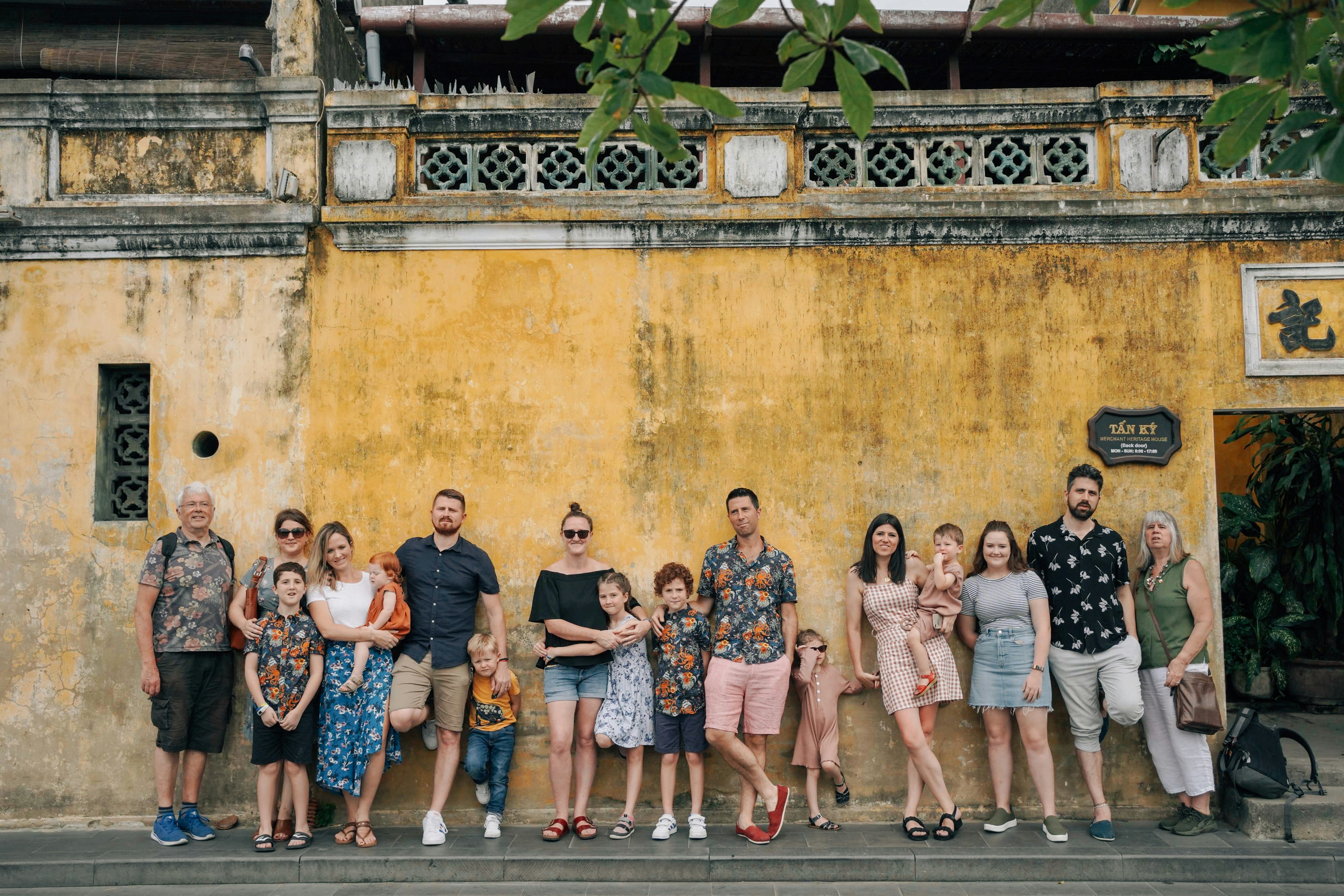 A group of people posing for a photo in front of a building photo ...