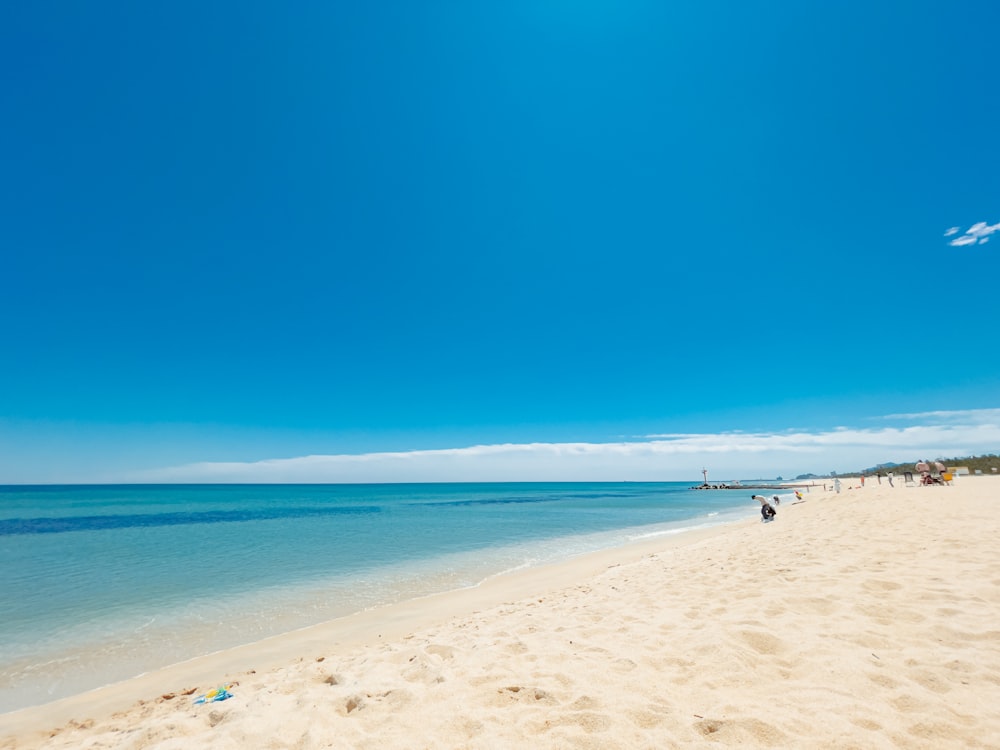 a sandy beach with blue water