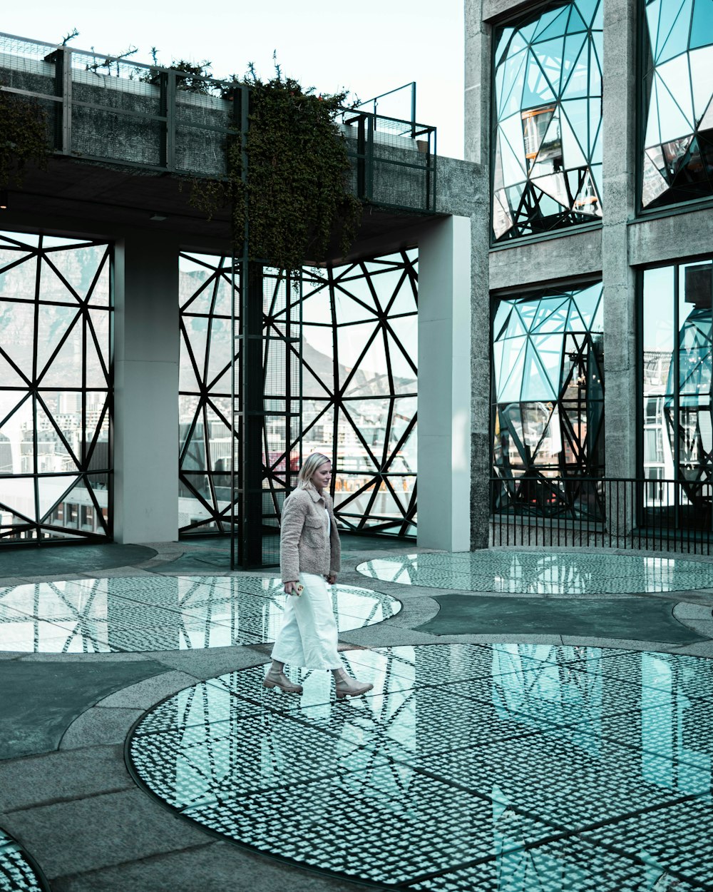 uma pessoa em pé na frente de um edifício de vidro