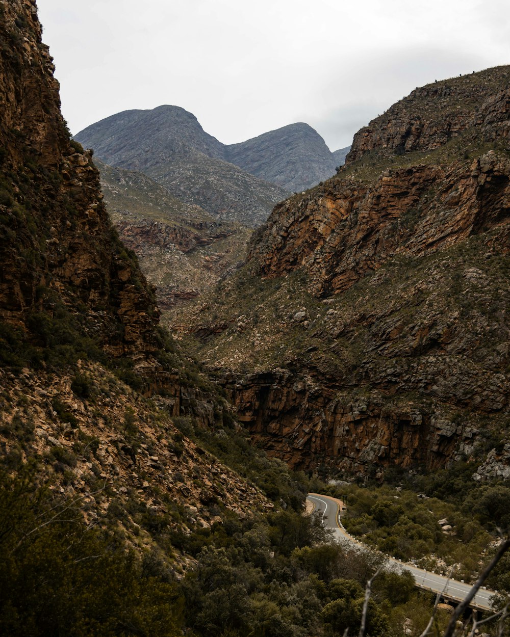 a winding road through a valley between mountains