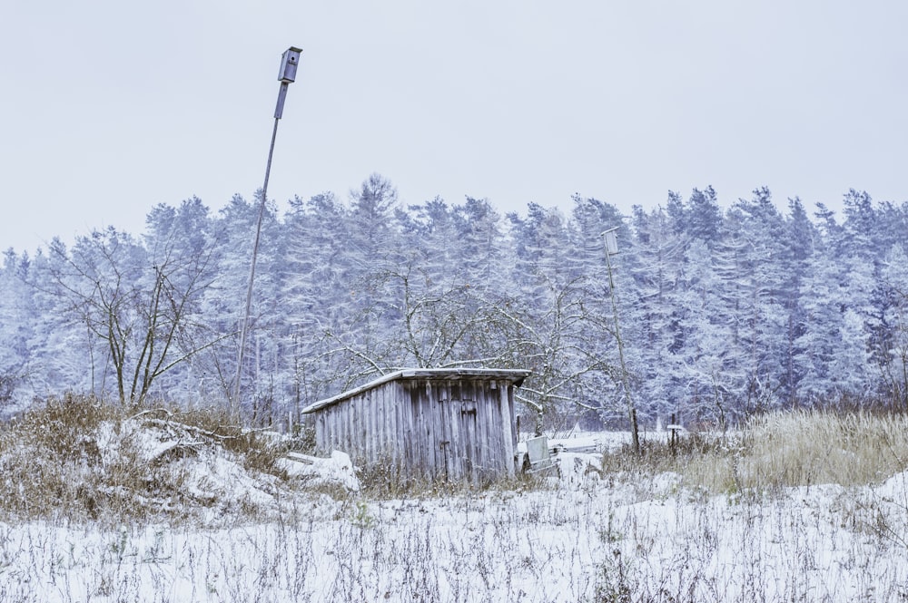 a small shack in a snowy field