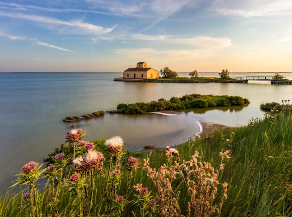 a body of water with a building on the shore