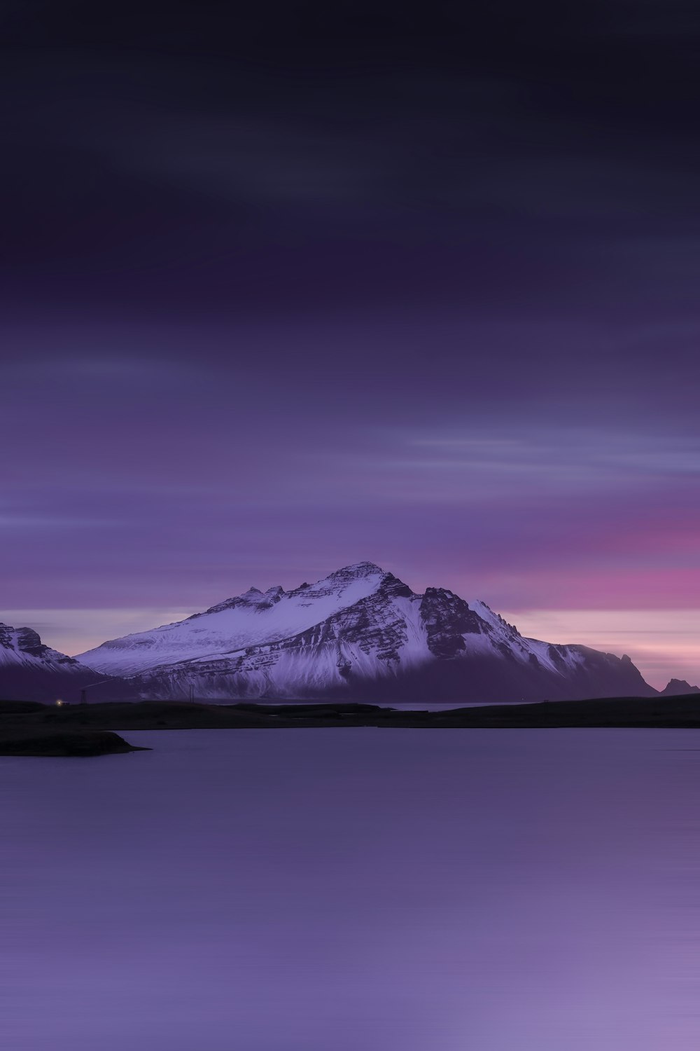 a snowy mountain with a purple sky