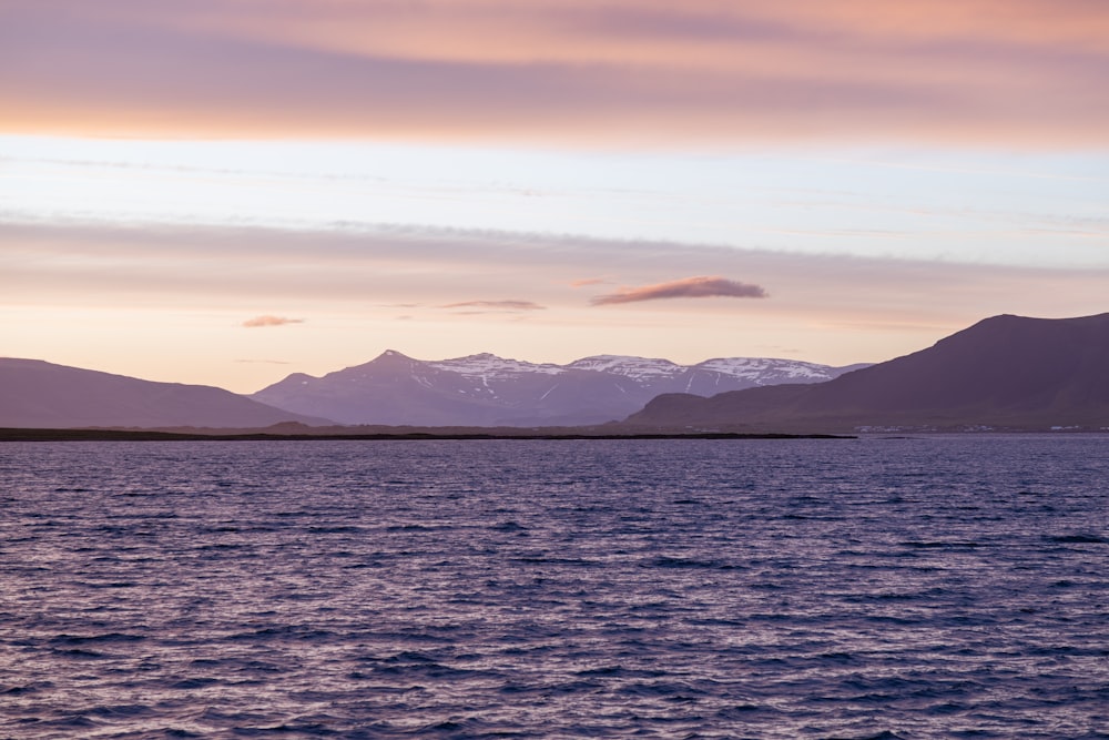 a body of water with mountains in the background