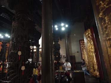 Close-up of a storyteller animatedly sharing tales, framed by carved wooden screens and deep olive accents.