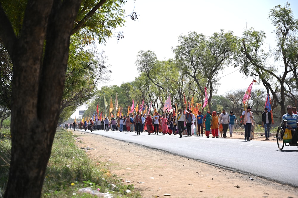 a group of people walking on a road with flags
