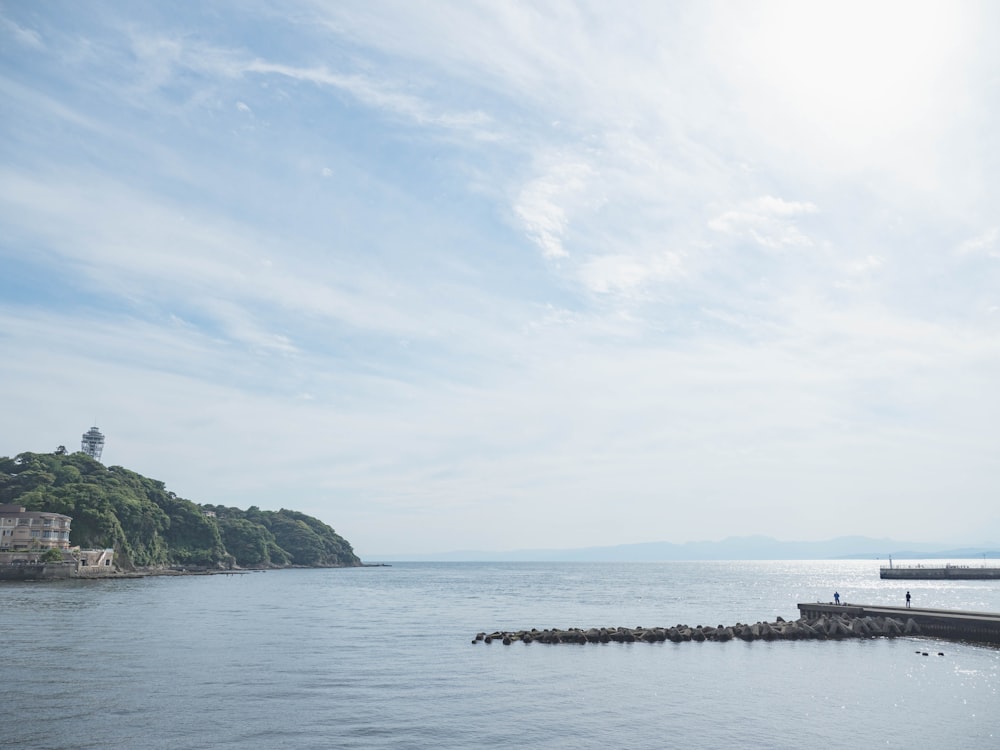 a body of water with a dock and a land with trees on it