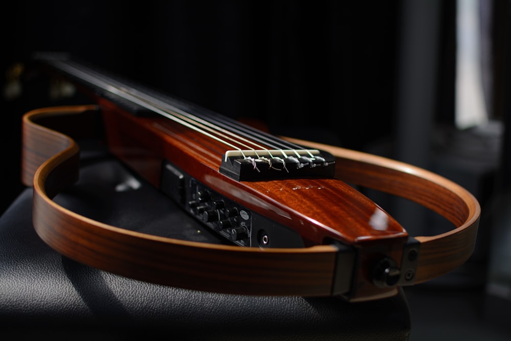 a brown guitar on a black surface