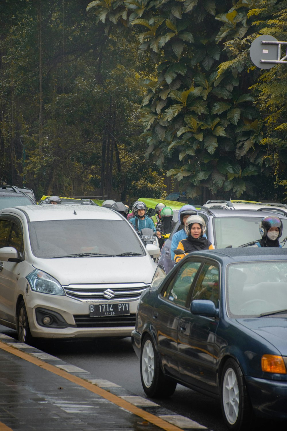 a group of people in helmets and rain gear on a road