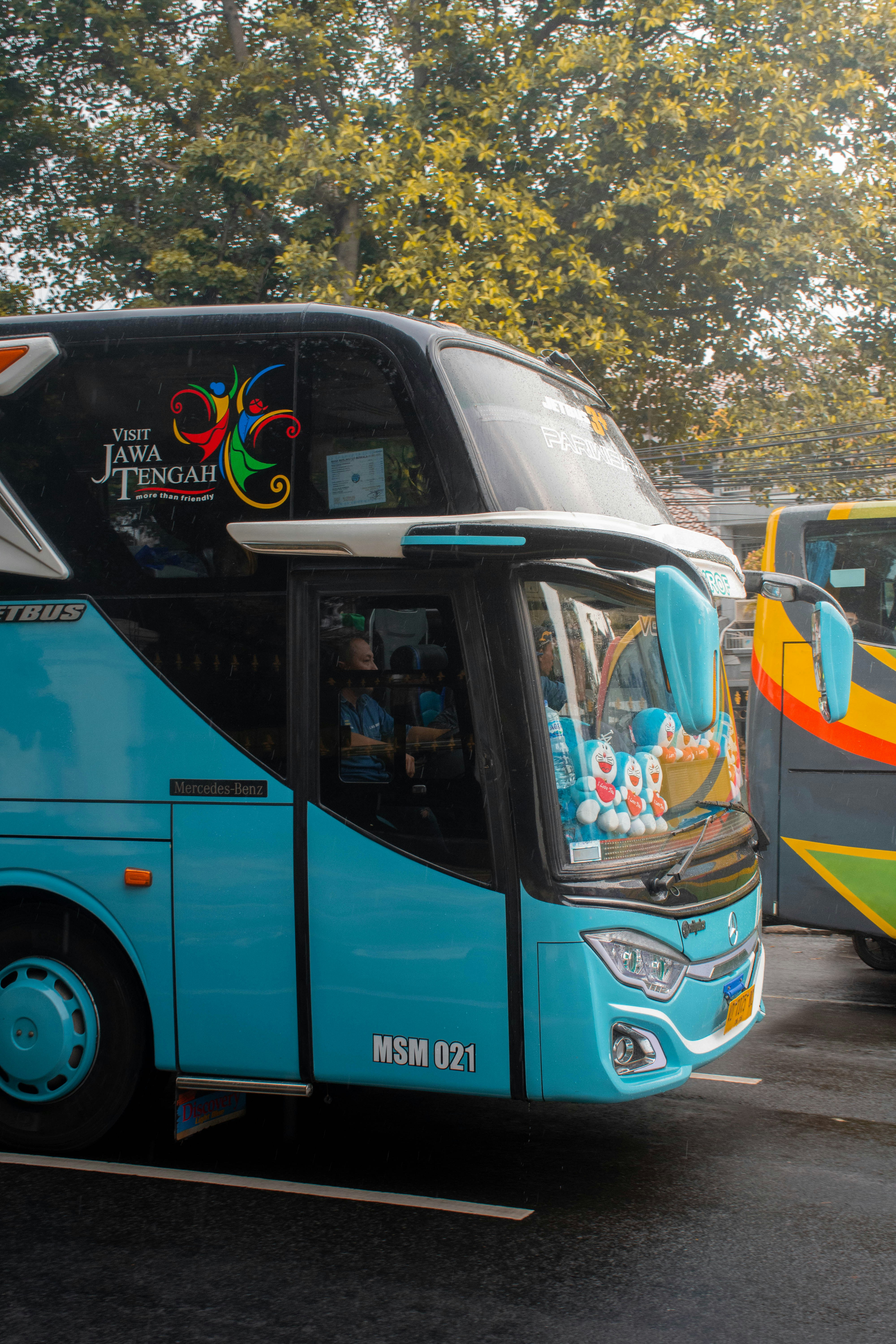 Sebuah bus biru diparkir di pinggir jalan