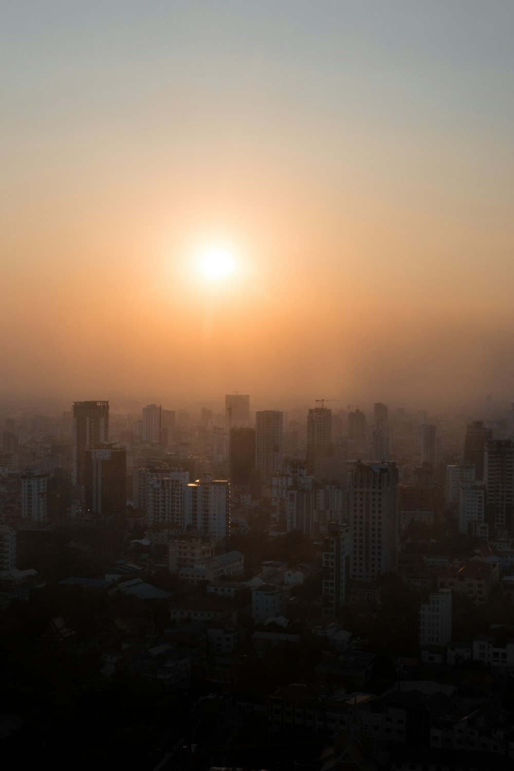 a city skyline with the sun setting