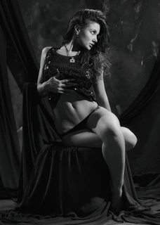 A high-fashion portrait of a model in dramatic lighting showcasing elegant boudoir style.