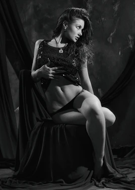 A tasteful, sensual portrait of a confident woman in soft lighting.