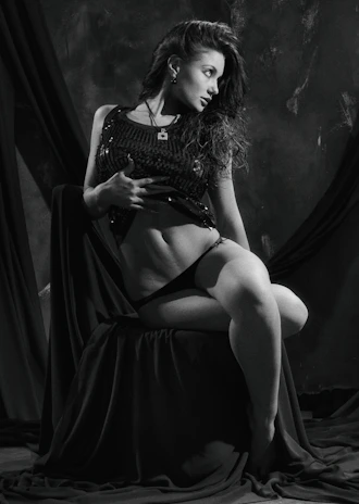 A tasteful, sensual portrait of a confident woman in soft lighting.