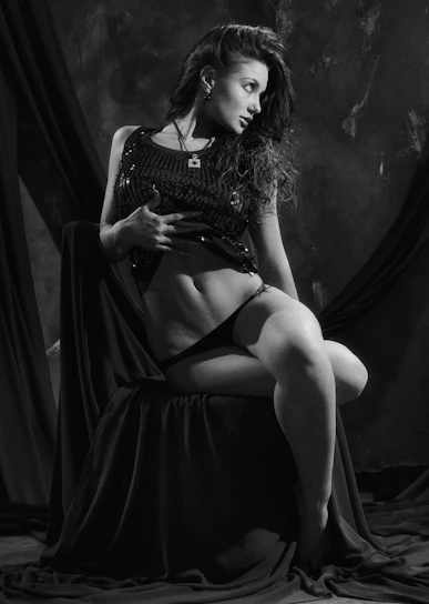 A tasteful, sensual portrait of a confident woman in soft lighting.