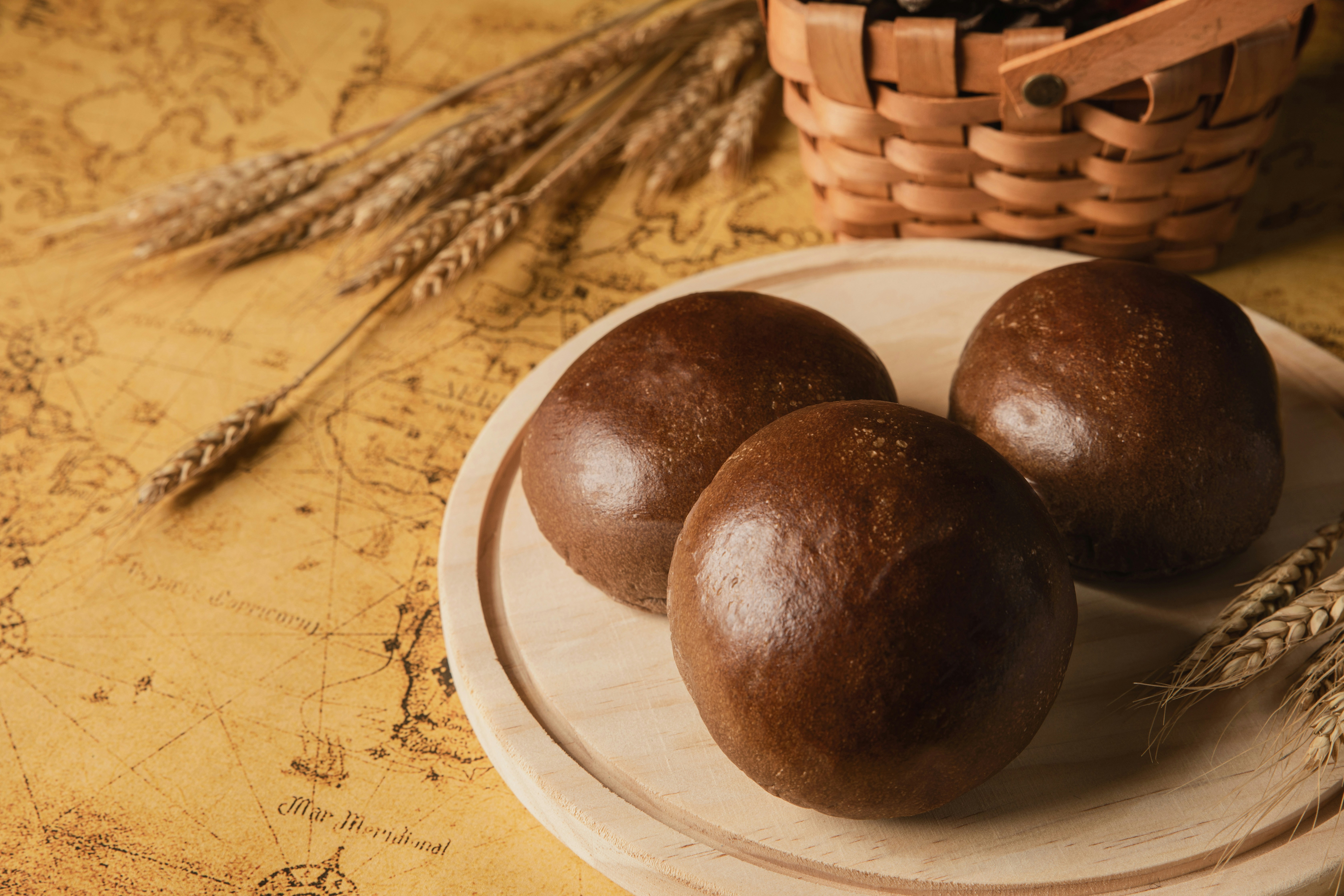 Tiga roti cokelat bulat di atas piring kayu