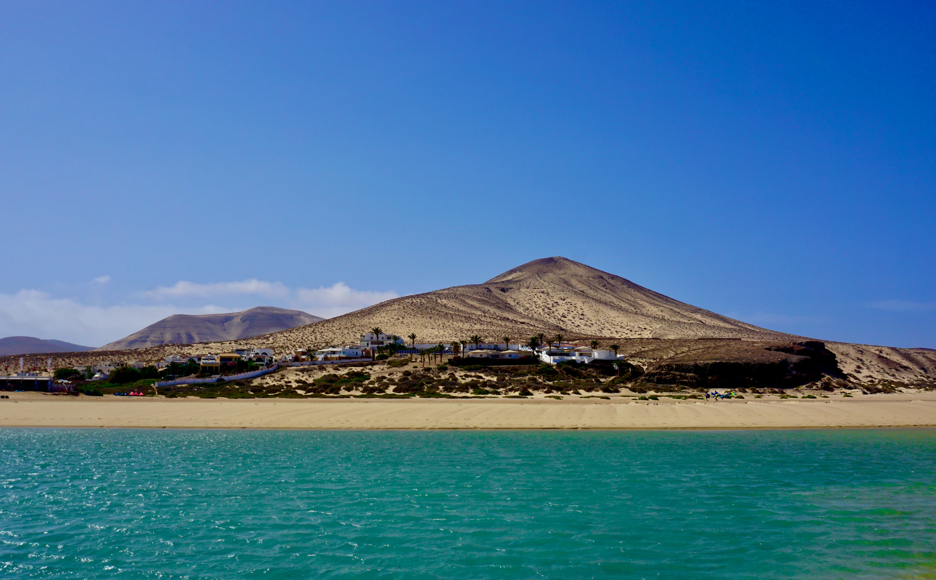 a large hill next to a body of water