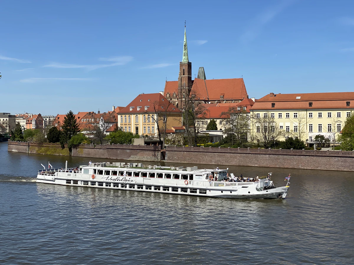 River cruise ship sailing past historic riverside buildings in Europe