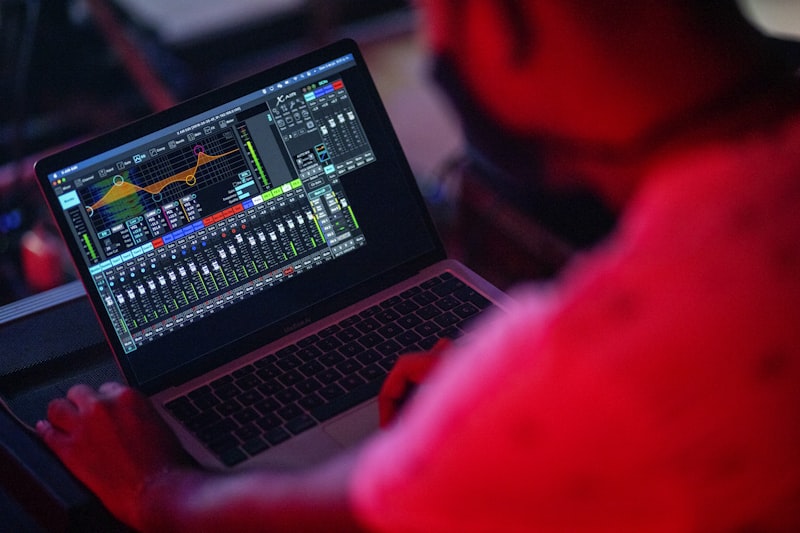 Producer using AI tools on laptop to accelerate beat production workflow