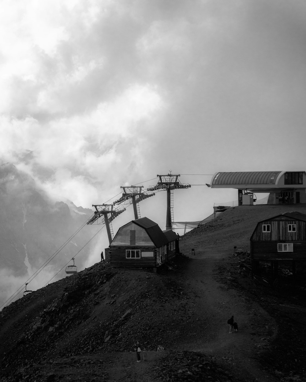 a group of buildings next to a hill with a person walking on it