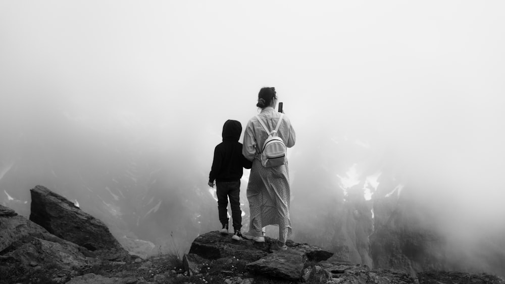 a group of people standing on a rock with fog around them